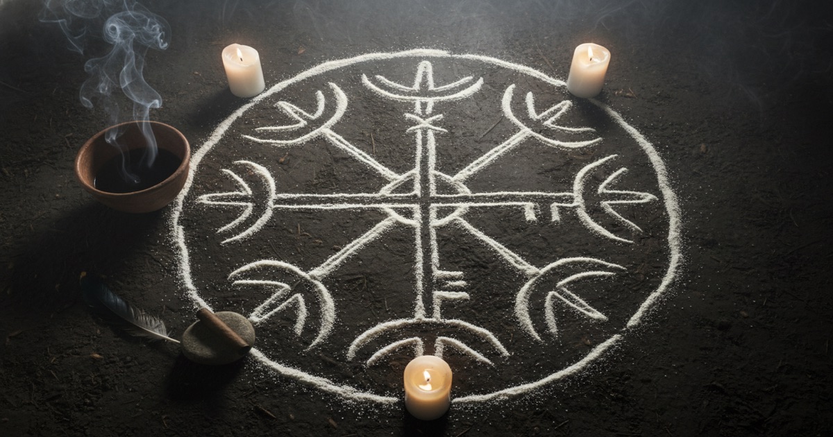 Vèvè de Papa Legba — symbole rituel vaudou dessiné en farine de maïs avec offrandes cérémonielles Vèvè (symbole rituel vaudou) complexe dessiné en farine de maïs blanche sur un sol de terre sombre — le motif géométrique symétrique représentant Papa Legba, entouré d'offrandes : bol d'argile avec rhum, trois bougies allumées, cigare, plume de coq — vue du dessus